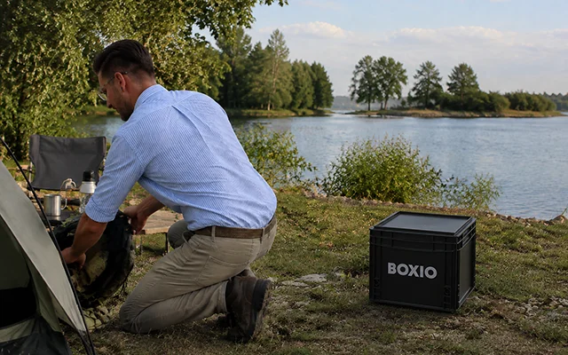 Leon setting up a BOXIO composting toilet at a lakeside tent pitch